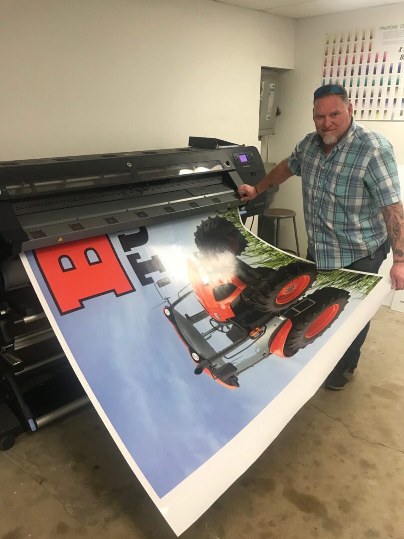 A man standing next to an image of a tractor.